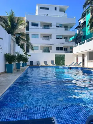a swimming pool in front of a building at La Boquilla Oasis - Charming 1-Bedroom Apartment with Pool in Cartagena de Indias