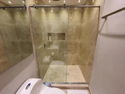 a glass shower in a bathroom with a toilet at Moderna suite frente al lago cerca a la playa in Cartagena de Indias