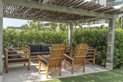 a patio with two chairs and a couch under a pergola at Luxury 2-Bedroom Apartment with Breathtaking Ocean Views in Cartagena de Indias
