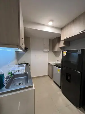 a kitchen with a sink and a black refrigerator at Exclusivo apartamento art zona norte in Cartagena de Indias