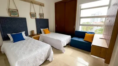 a room with two beds and a couch and a window at Magico Apartamento Frente al Mar 3 Habitaciones TR52 in Coveñitas