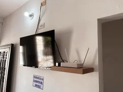 a television sitting on a wall with a wooden shelf at Madili del Mar II in Santiago