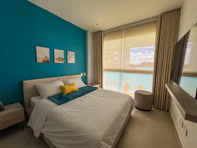 a bedroom with a large bed with a blue wall at 1 Alcoba Hermosa vista a la laguna + bote inflable in Los Arrayanes