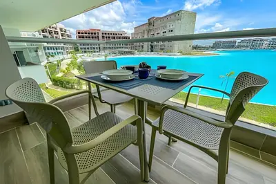 a table and chairs on a balcony with a view of a pool at 1 Alcoba Hermosa vista a la laguna + bote inflable in Los Arrayanes