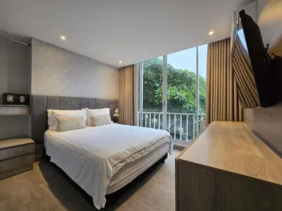 a bedroom with a bed and a large window at Apartamento con balcón y vista al lago in Cartagena de Indias