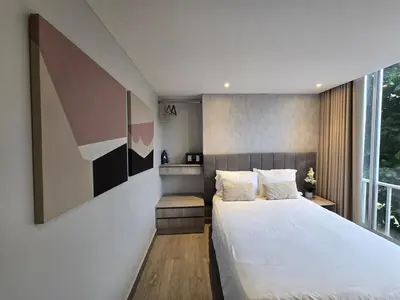 a bedroom with a large white bed and a window at Apartamento con balcón y vista al lago in Cartagena de Indias