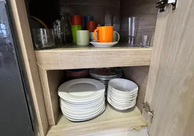 a cabinet with a stack of plates and cups at Cabaña de ensueño en Coveñas in Puerto Viejo