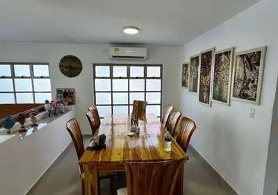 a dining room with a wooden table and chairs at Cabaña de ensueño en Coveñas in Puerto Viejo