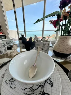 a white bowl with a spoon on a table with vases at Exclusive apartment with ocean view in Cartagena de Indias