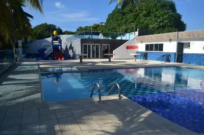 an empty swimming pool with a playground and a building at Hermosa Cabaña C15, Castillo Club in Coveñas