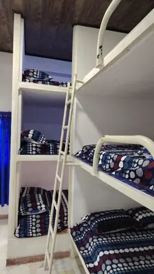 a ladder on a shelf in a room with bunk beds at CARTAGENA BOQUILLA BEACH HOSTEl in Cartagena de Indias