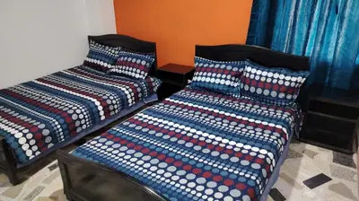two beds with colorful pillows sitting next to each other at CARTAGENA BOQUILLA BEACH HOSTEl in Cartagena de Indias