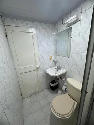 a white bathroom with a toilet and a sink at Edificio frente a la playa en cartagena, marbella in Cartagena de Indias