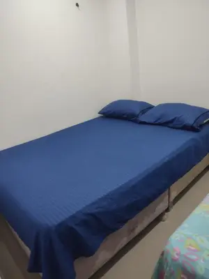 a bed in a room with blue sheets and pillows at Torices casa hostal 47 in Cartagena de Indias