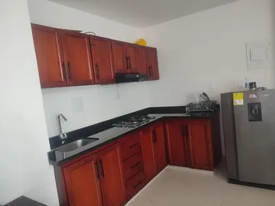 a kitchen with wooden cabinets and a stainless steel refrigerator at Torices casa hostal 47 in Cartagena de Indias
