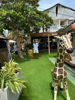 a statue of a giraffe sitting on the grass at Hospedaje de lujo baru in Playa Blanca
