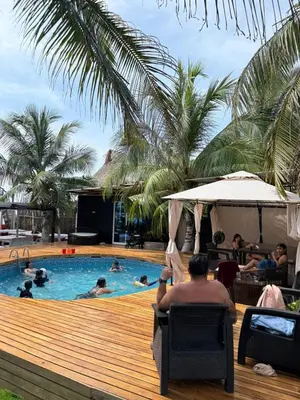 a man sitting in a chair next to a swimming pool at Hospedaje de lujo baru in Playa Blanca