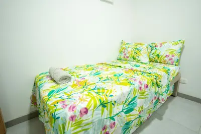 a bed with a colorful comforter and a pillow at Apto moderno, Vista al mar, 3Hab cerca de la playa in Cartagena de Indias