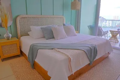 a bedroom with a large bed with pink and grey pillows at Disfruta el espectáculo de la bahía in Cartagena de Indias