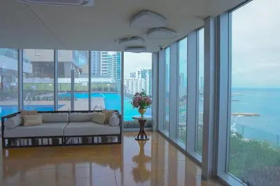 a living room with a couch in a room with windows at Disfruta el espectáculo de la bahía in Cartagena de Indias