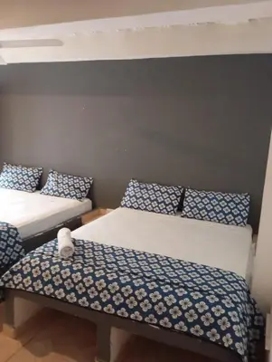 a room with two beds with blue and white pillows at Hotel Nativo Manzanillo in Cartagena de Indias