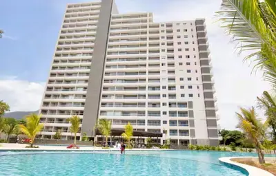 a large building with a swimming pool in front of a building at Apartamento de lujo en Santa Marina Santa Marta in Santa Marta