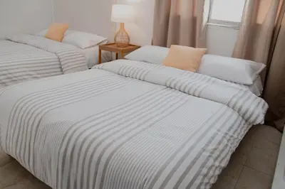 two beds with striped sheets in a room at Comfortable apartment in the historic center in Cartagena de Indias