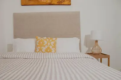 a bed with a striped comforter and two pillows at Comfortable apartment in the historic center in Cartagena de Indias