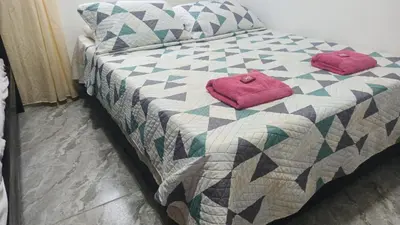 a bed with two pink pillows on top of it at Apartamento M&M in Coveñas