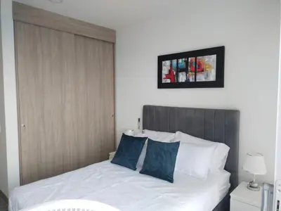 a bedroom with a white bed with blue pillows at Estrene en Santa Marta vía Barranquilla a 10 minutos aeropuerto, acceso y vista al mar in Santa Marta