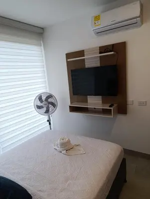 a room with a bed with a fan and a television at Estrene en Santa Marta vía Barranquilla a 10 minutos aeropuerto, acceso y vista al mar in Santa Marta