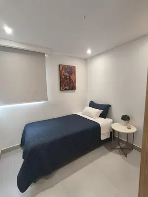 a bedroom with a blue and white bed and a table at Apartamento Luxury en Cartagena con Vista al mar in Cartagena de Indias