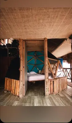 a small bed in a wooden room with a window at Hostal Ananda in Playa Blanca