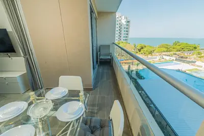 a balcony with a table and chairs and a pool at Elemnt Rentals in Santa Marta