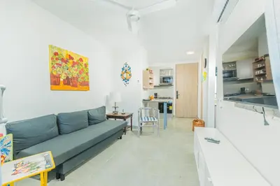a living room with a couch and a kitchen at Elemnt Rentals in Santa Marta