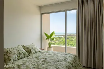 a bedroom with a bed and a large window at Elemnt Rentals in Santa Marta