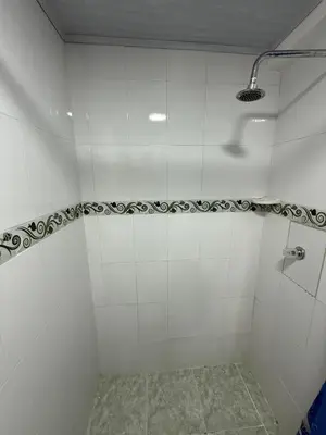 a bathroom with a shower with white tiled walls at Hermoso estudio en Cartagena edificio frente al mar in Cartagena de Indias