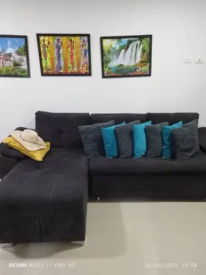 a black couch with blue pillows in a living room at Apartamento turístico cerca al mar en Cartagena in Cartagena de Indias