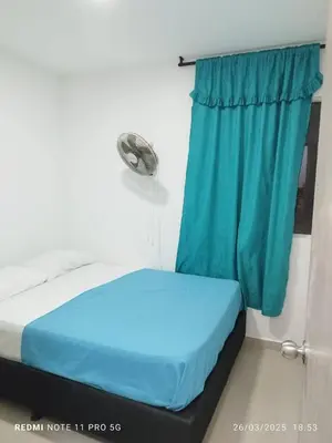 a bed in a room with a blue curtain at Apartamento turístico cerca al mar en Cartagena in Cartagena de Indias