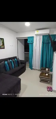 a living room with a couch and blue curtains at Apartamento turístico cerca al mar en Cartagena in Cartagena de Indias