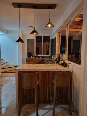 a kitchen with a island with two bar stools at HELENA Beach House in La Rada
