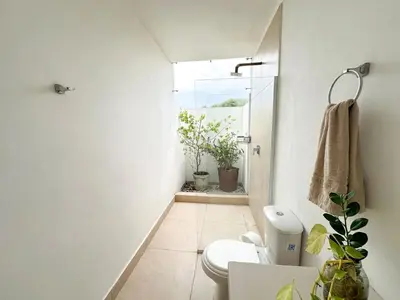 a bathroom with a toilet and a window with plants at Apartment for 8 Guests in Sabanilla a few steps from the Sea in Maizal