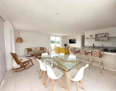 a living room with a glass table and white chairs at Apartment for 8 Guests in Sabanilla a few steps from the Sea in Maizal