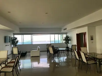 a large room with tables and chairs and windows at Cartagena Excelente Apartamento in Cartagena de Indias