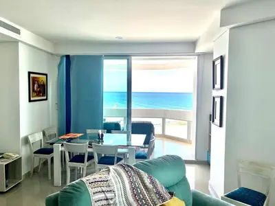 a living room with a couch and a table with a view of the ocean at Cartagena Excelente Apartamento in Cartagena de Indias