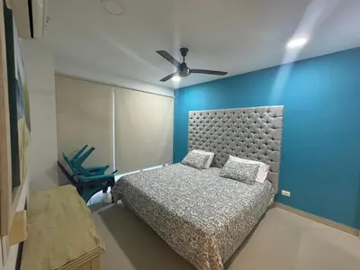 a bedroom with a bed and a blue wall at Apartamentos Mi Reserva OK - Arrecife in Coveñas