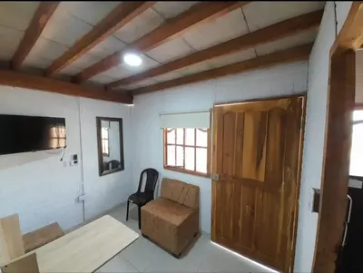 a room with a chair and a table and a door at Cabaña Barbacoas1 in Santa Ana