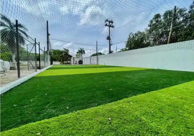 a soccer field with a fence and green grass at Quinta San Gabriel House in Turbaco
