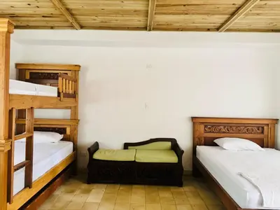 a room with two bunk beds and a bench in it at Quinta San Gabriel House in Turbaco