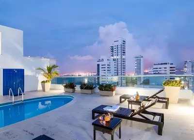 a rooftop patio with a pool and a city skyline at Apartamento con vista al mar - Piscina en la azotea - 2 habitaciones + 2 baños in Cartagena de Indias